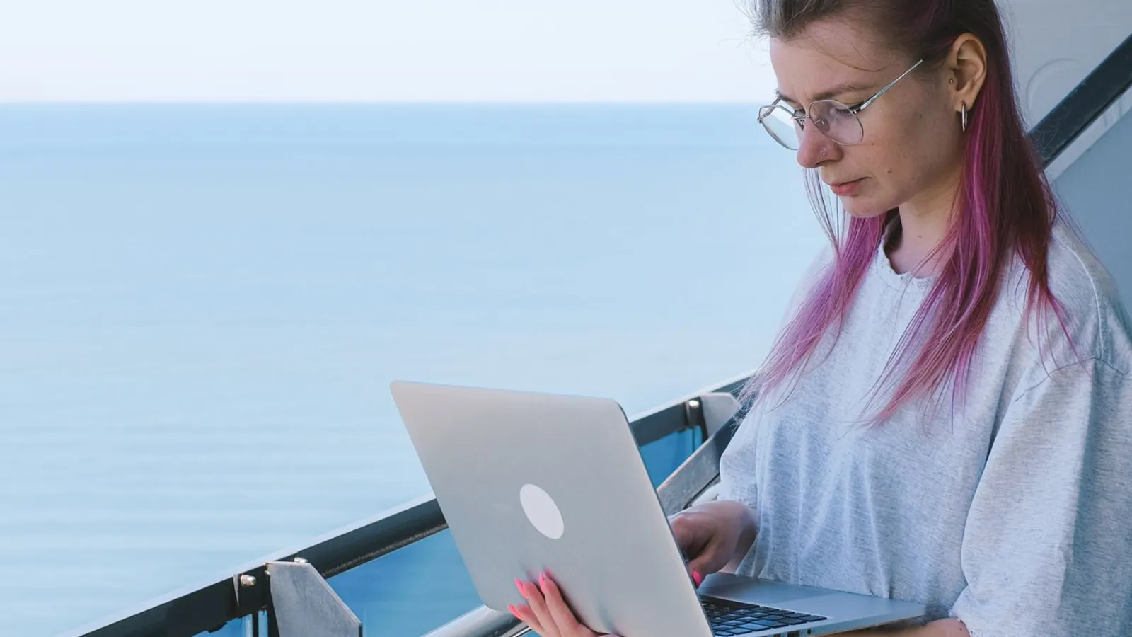 A nomad working on a laptop above the sea