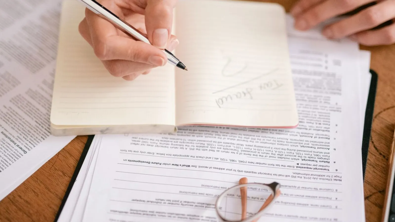 Filling in tax paperwork beside a notebook